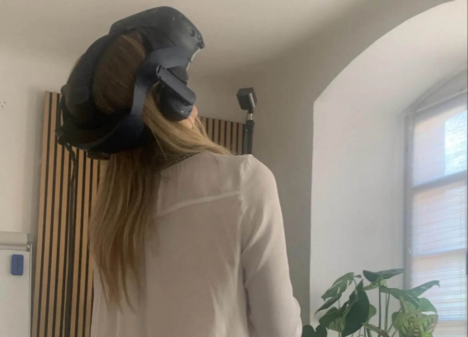 Person mit VR-Brille in einem hellen Therapieraum.
