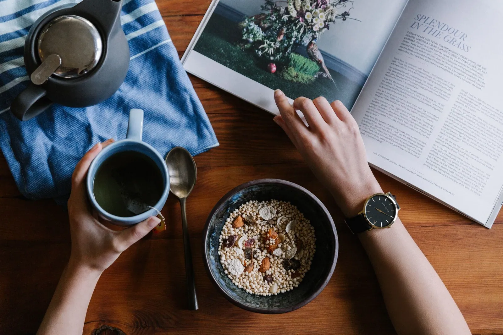 Zwei Menschen an einem Tisch mit Kaffee und einem aufgeschlagenen Buch.